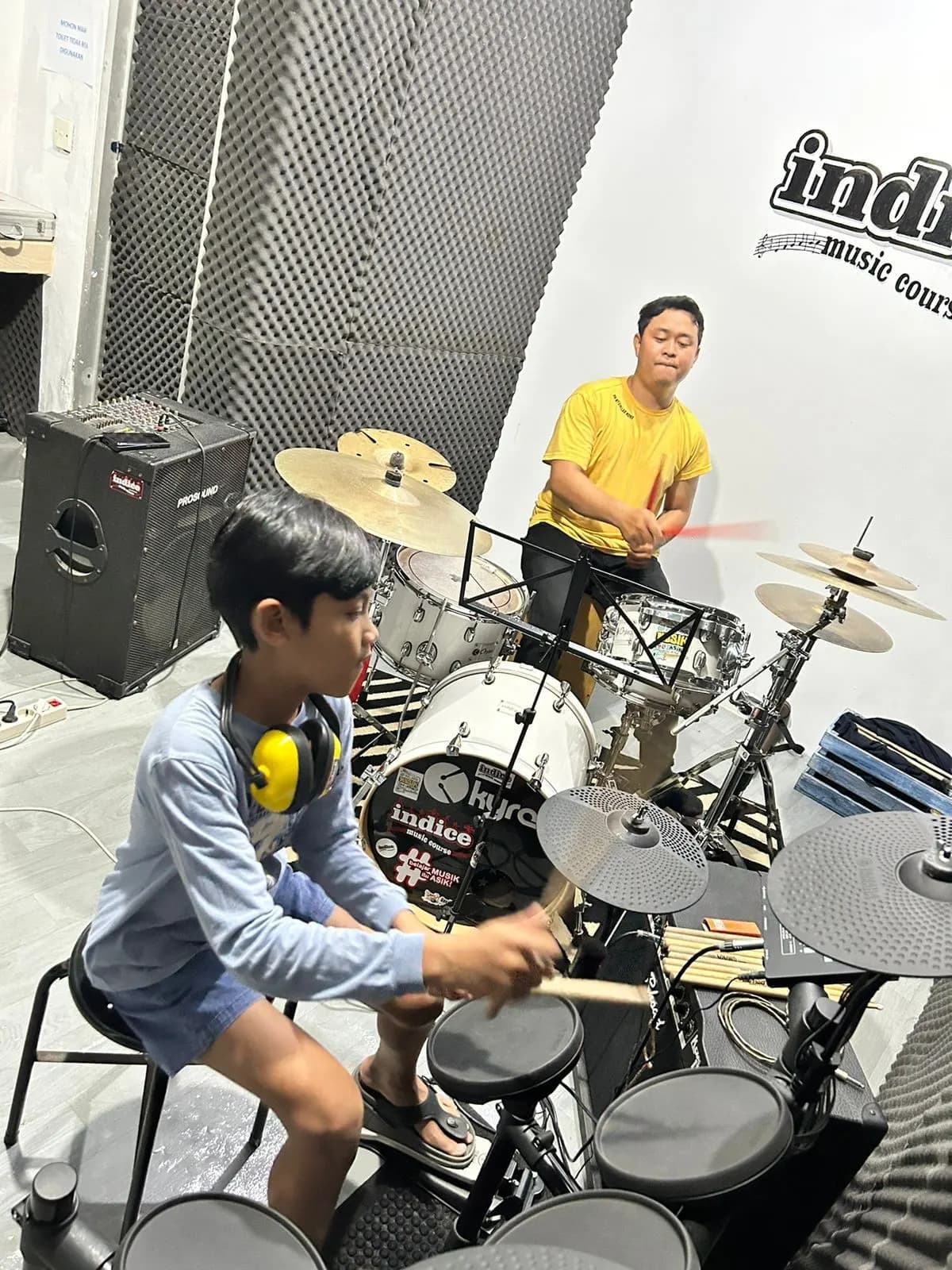 Guru drum Indice mendampingi murid di studio