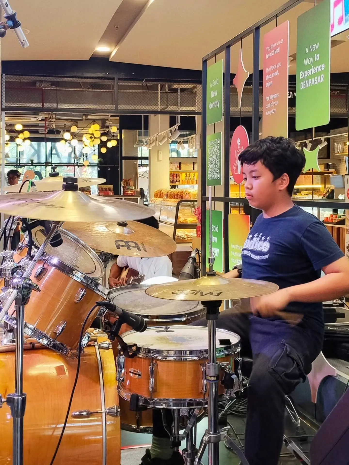 Murid drum remaja bermain di panggung mall